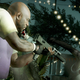 A man points a sub-machine gun at a clown zombie as it rushes toward him.